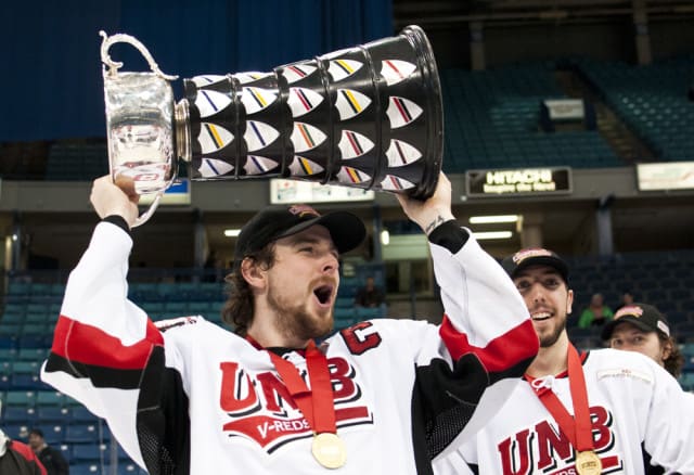 University of New Brunswick's captain Chris Culligan hoists the University Cup after defeating the Saint Mary's Huskies 2-0 for the national title.