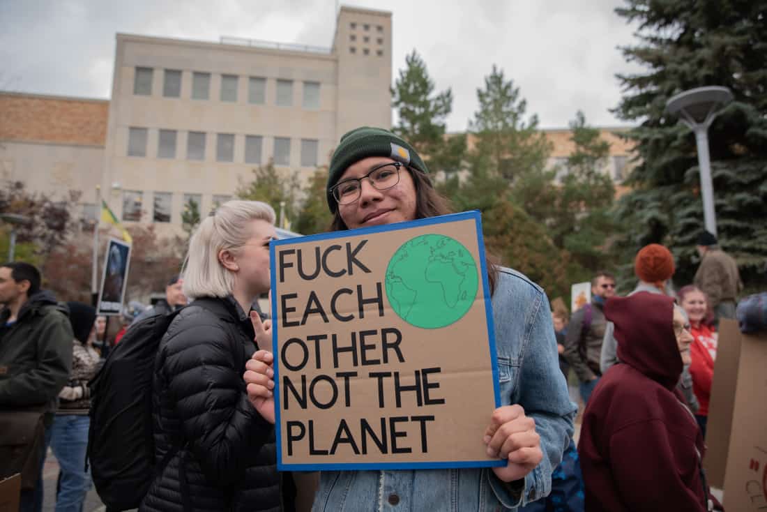 A climate activist poses with their sign for the Global Climate Strike at the Saskatoon City Hall on Sept. 27, 2019.