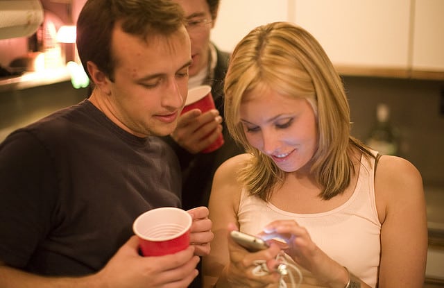 people looking at their smartphones at a party