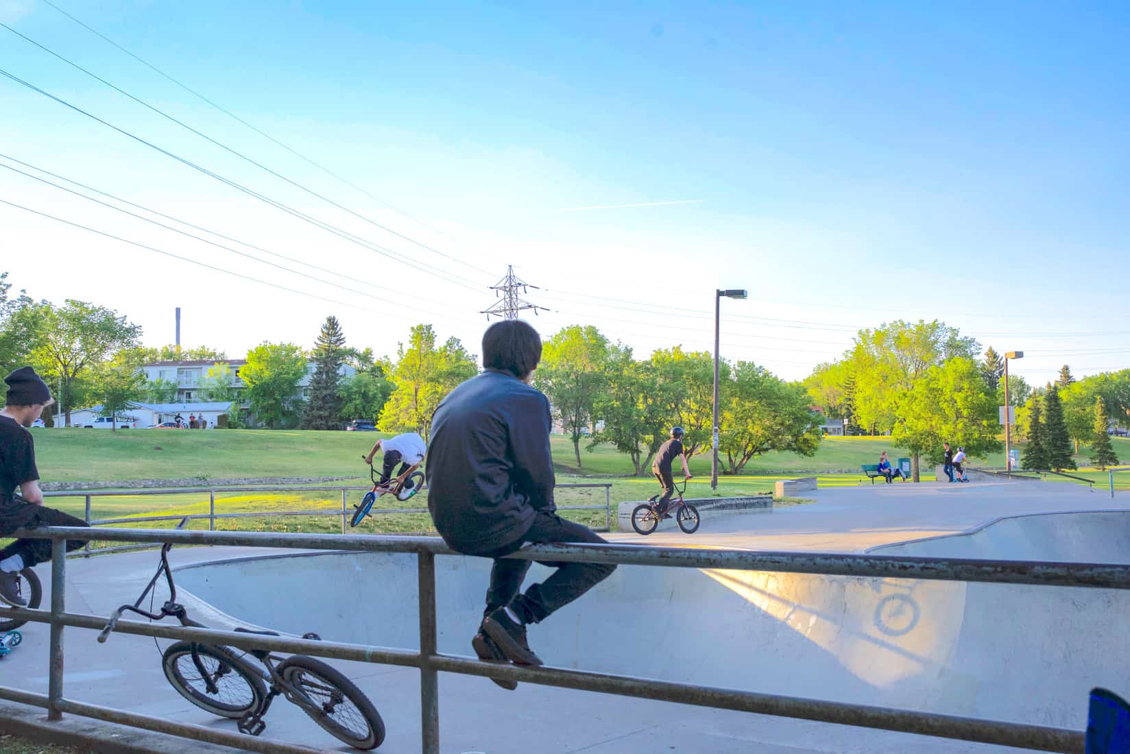 A spectator faces the Lions Skatepark in Saskatoon as riders practice in the background on June 12, 2019.