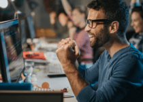 Cheerful computer programmer celebrating success in the office | skynescher from Getty Images Signature | Canva Pro