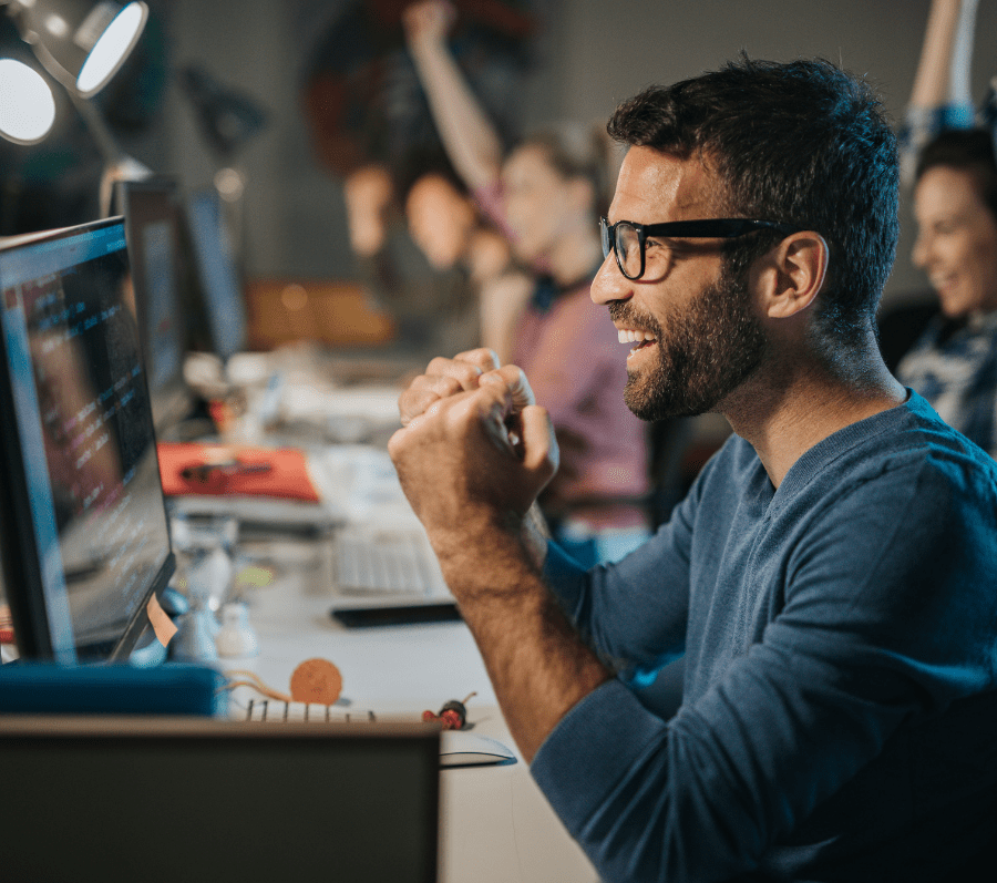 Cheerful computer programmer celebrating success in the office | skynescher from Getty Images Signature | Canva Pro