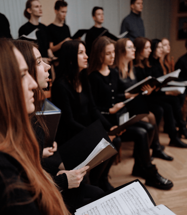 A choir sining while holding their music sheets | Thirdman from Pexels | Canva Pro