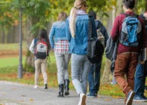 University students walking on campus | Simonkr Getty Images Signature | Canva Pro