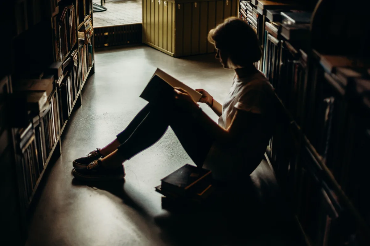A woman sitting on the floor reading a book | Cottonbro Studio from Pexels | Canva Pro