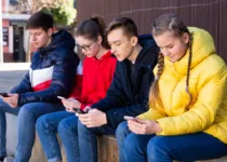 Teens with phones outdoors | Jack F Getty Images | Canva Pro