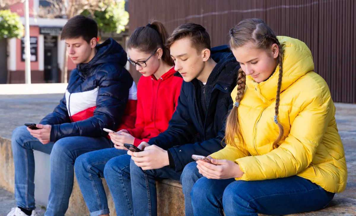 Teens with phones outdoors | Jack F Getty Images | Canva Pro