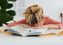 Girl sleeping with her head on books | Karola G from Pexels| Canva Pro