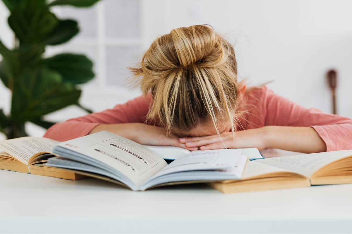 Girl sleeping with her head on books | Karola G from Pexels| Canva Pro