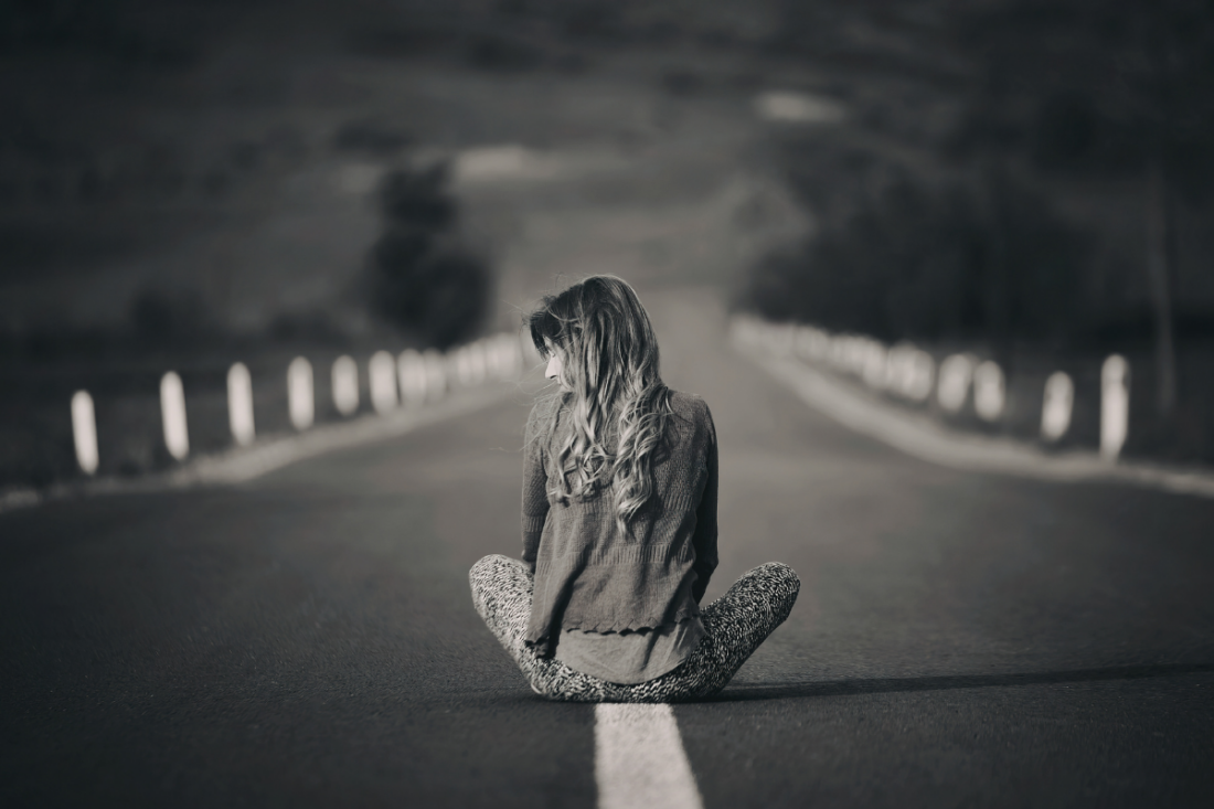 Woman sitting alone on an empty road | Elisabeta Dirjan’s Images| Canva Pro