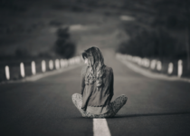 Woman sitting alone on an empty road | Elisabeta Dirjan’s Images| Canva Pro